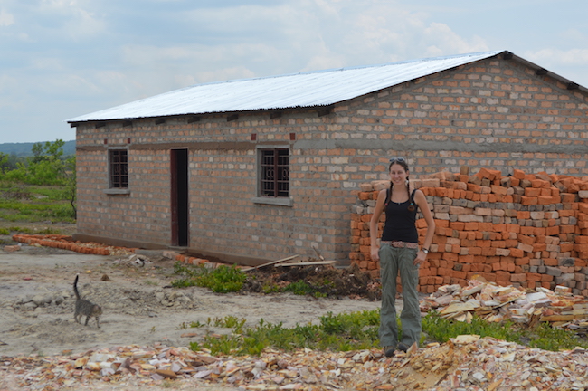 Leandra Merz in front of a brick building in Zambia 