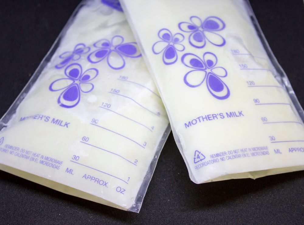 Two full bags of stored breast milk on a table