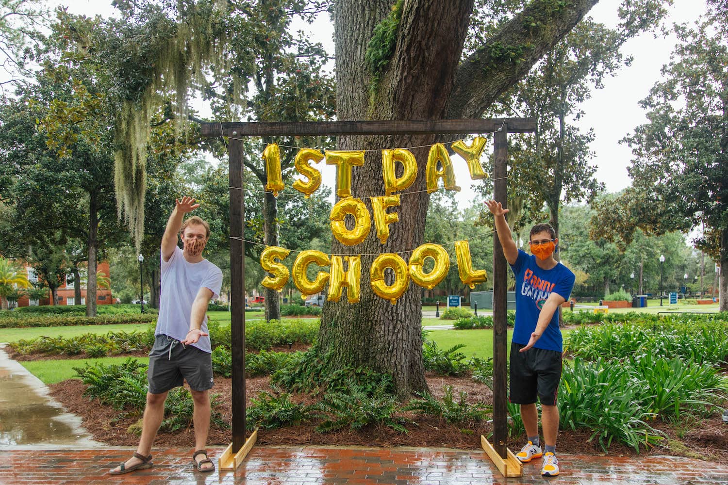 two students pose with a first day UF balloon sign
