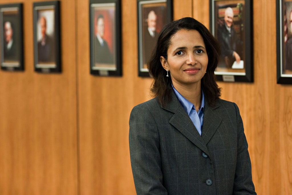 professor elizabeth rowe in a hallway lined with photos at Uf Law