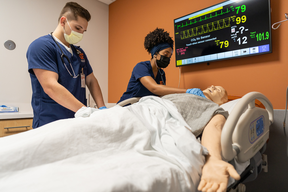 Students practice nursing techniques on a dummy in the newly renovated learning center