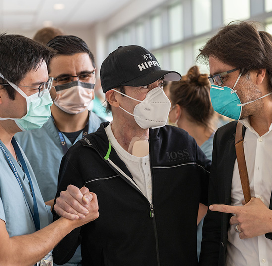 Surgical director Tiago Machuca, M.D., Ph.D., (left) and medical director Andres Pelaez, M.D., (right) congratulate a lung transplant patient (center) on his discharge. The research study emphasized the importance of multidisciplinary teams throughout the critical decision-making process.