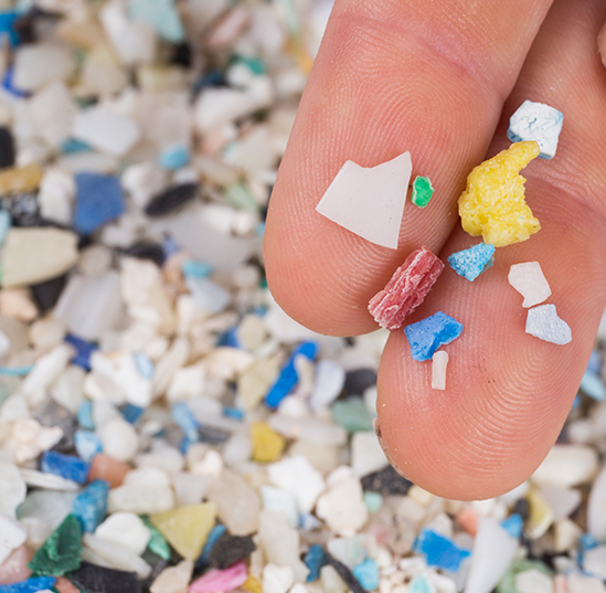 A close-up photo of microplastics on two fingers