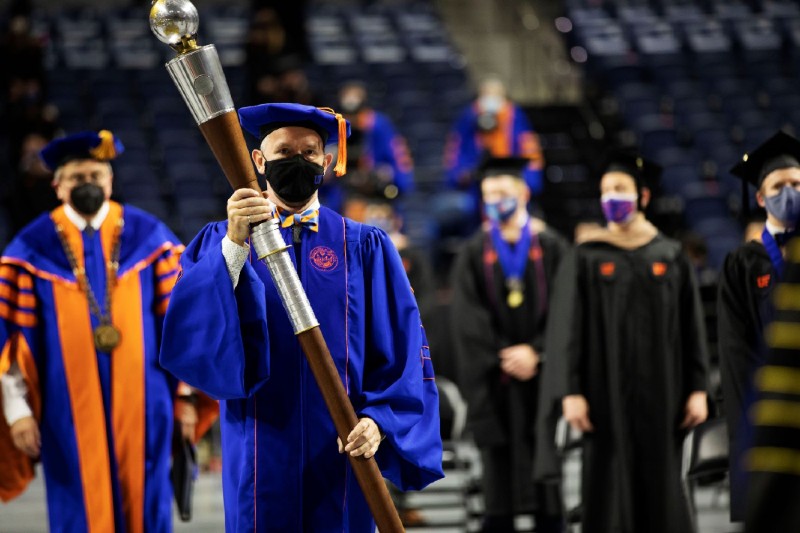 Dr. Hans van Oostrom carries UF's ceremonial mace during commencement.