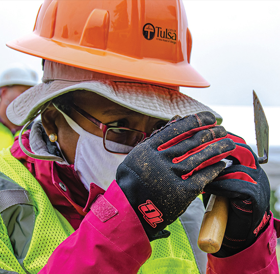 Phoebe Stubblefield examines something in her hands while she takes part in an excavation of Oaklawn Cemetery in Tulsa