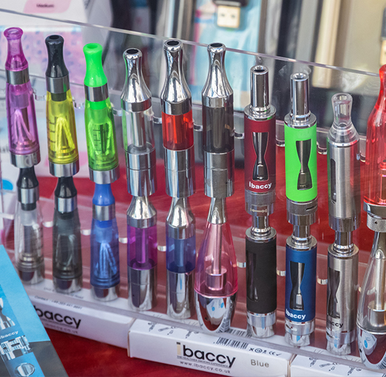 A collection of vape pens stand on display at a store.