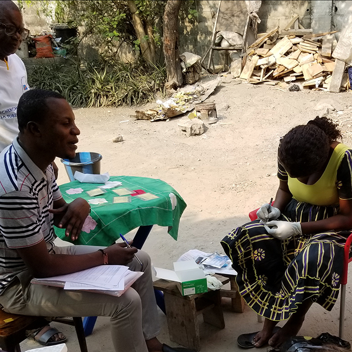 Health care workers and a community liaison (standing) work at a field site in Kinshasa, Democratic Republic of Congo for previous infectious disease research by Rhoel Dinglasan, Ph.D., M.P.H., and his team before the COVID-19 pandemic. Dinglasan will use the same field sites for a new project examining factors influencing COVID-19 severity in sub-Saharan Africa.