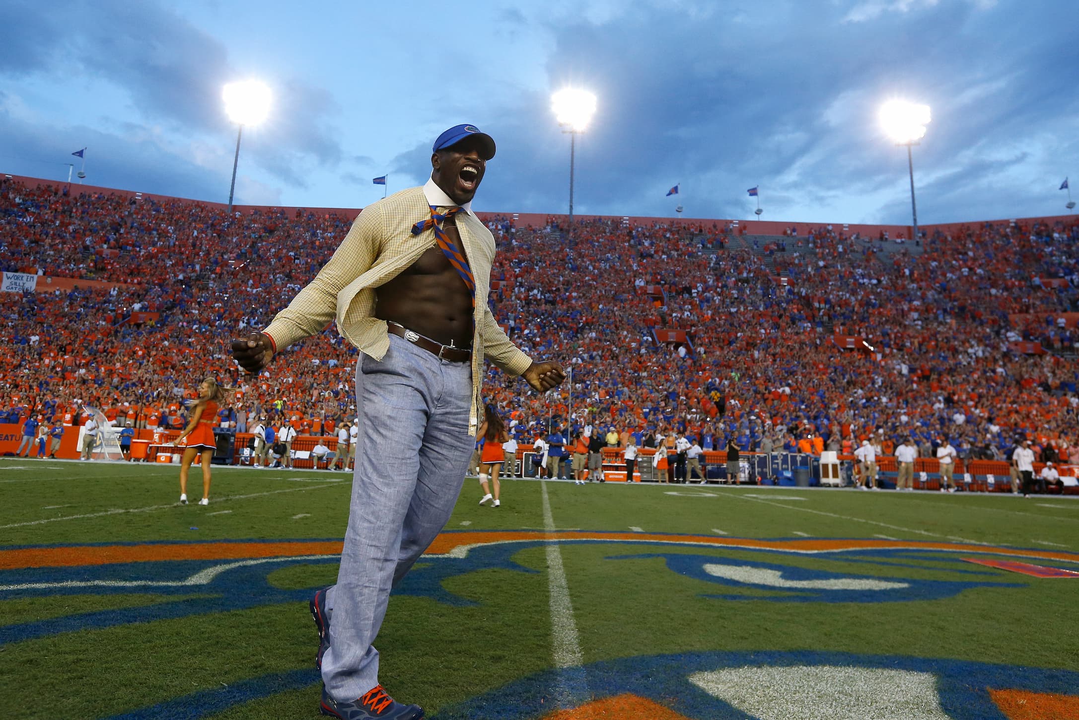 Titus O'Neil wears the signature yellow button up and seersucker pants of UF's Mr. Two-bits while running onto the UF football field