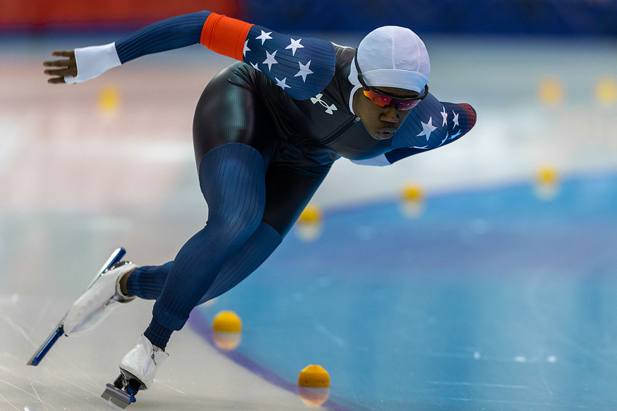 A female long track speed skater races on the ice.