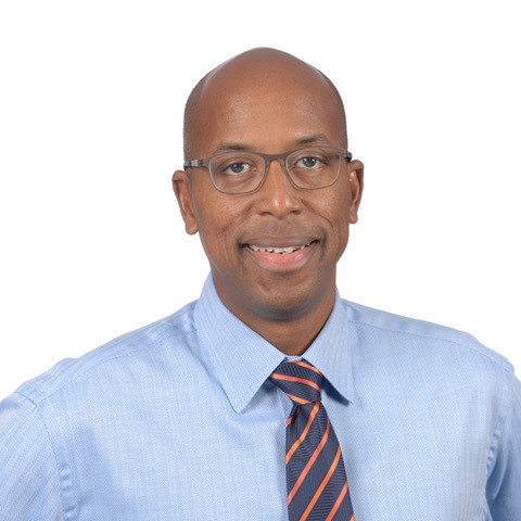 A portrait of David O. Prevatt. He is wearing a light blue dress shirt and an orange and blue striped tie. 