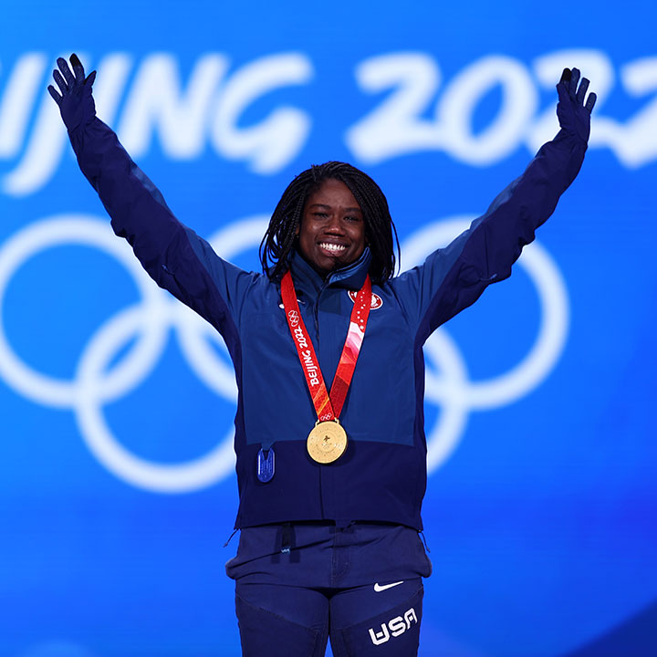 An Olympian stands celebrating her gold medal win