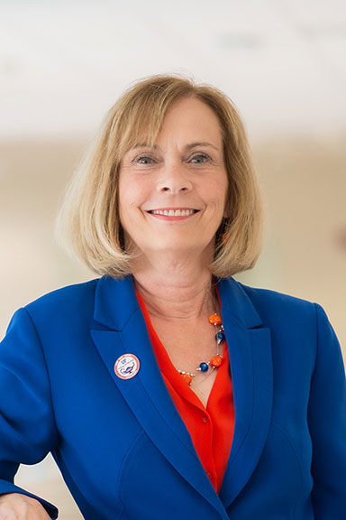 image of woman in blue jacket and orange blouse