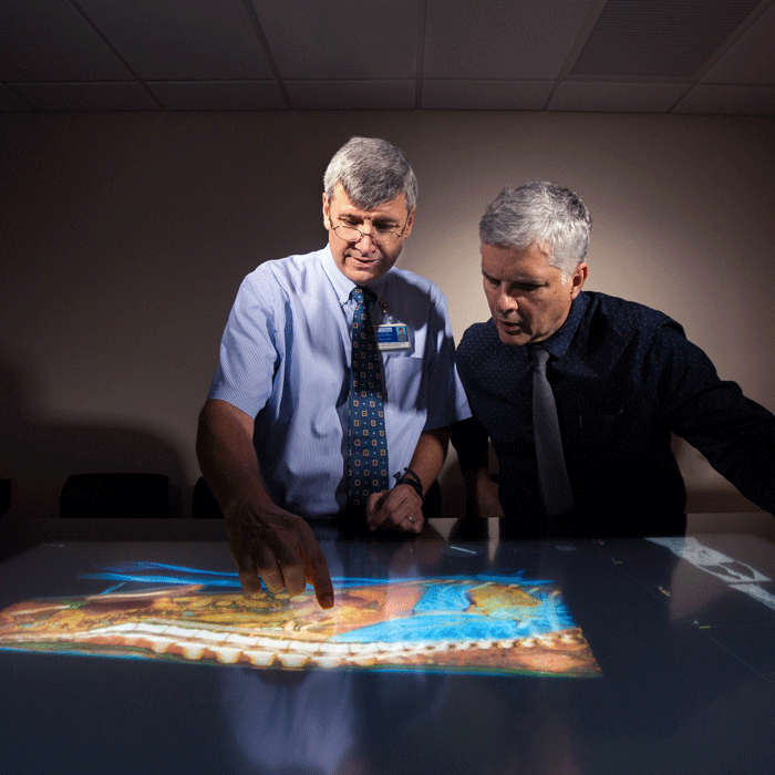 Two men study a smart map.