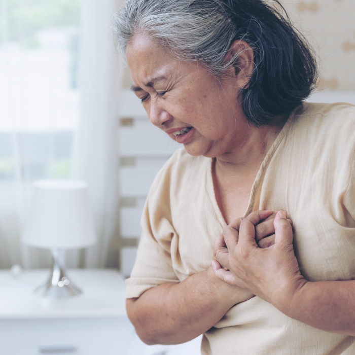 A woman clutching her chest in pain