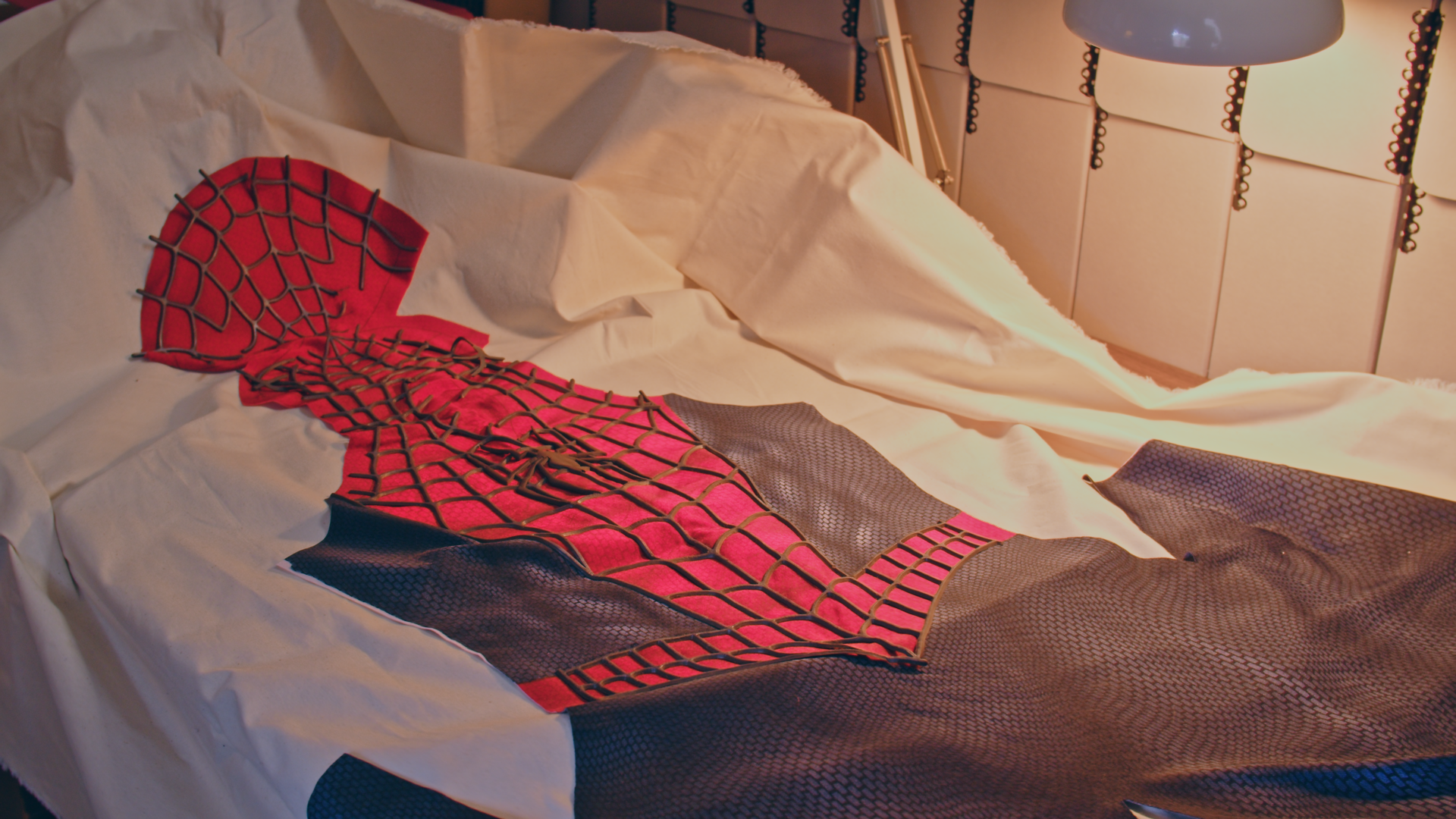 A Spider-Man suit placed on a white sheet.