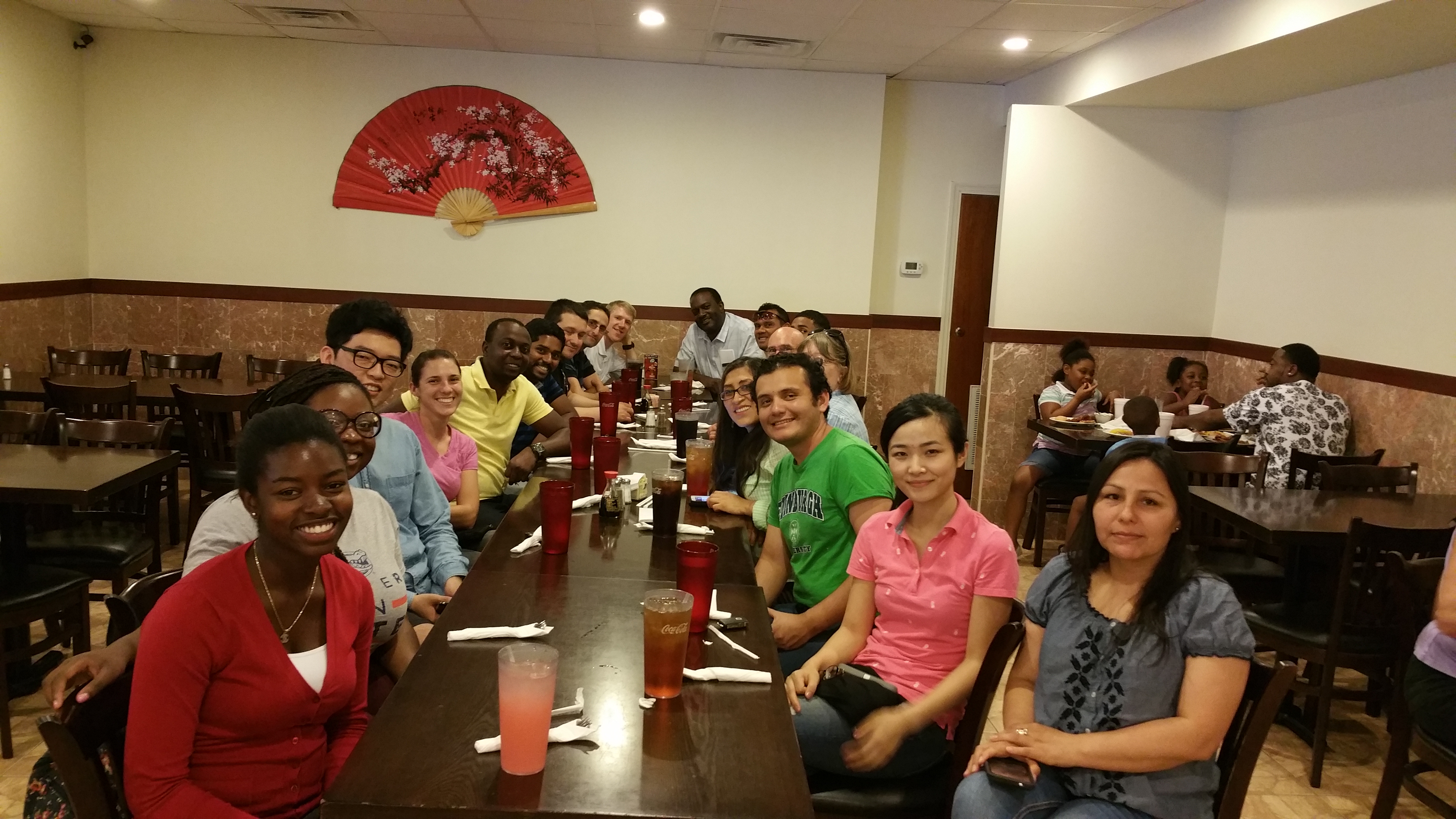 A group of students sit at a long table at a restaurant.