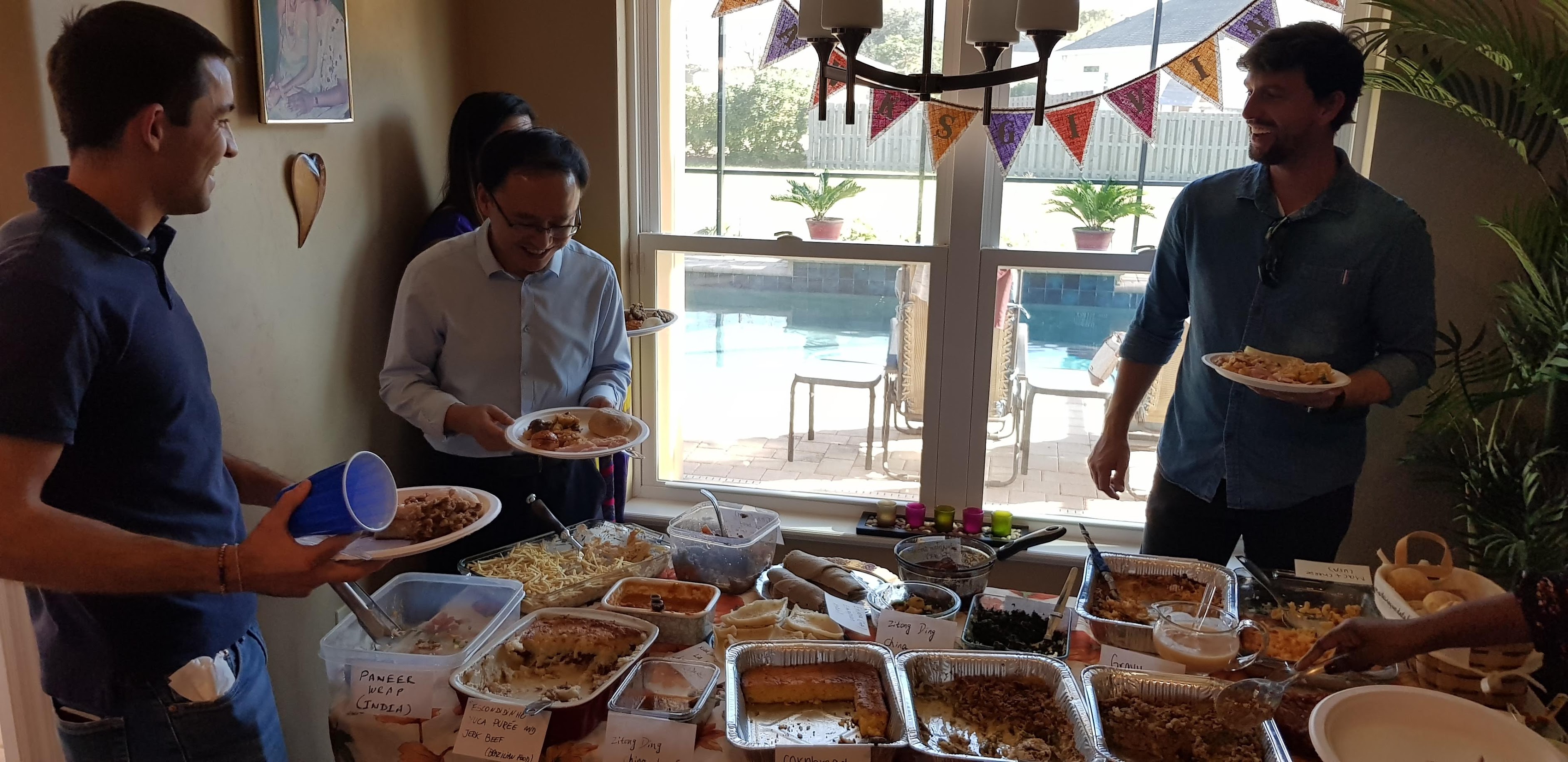 Students stand around a potluck table.