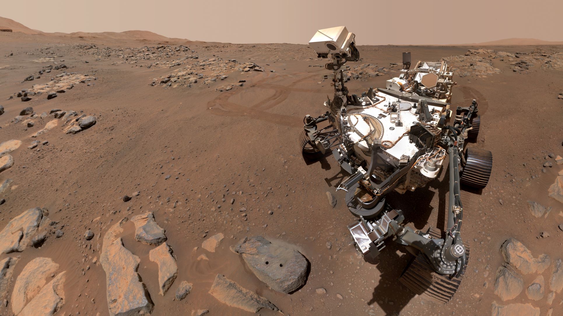 A picture of the Mars Perseverance rover looking at a rock on Mars