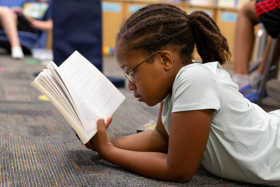 elementary school girl reading a book
