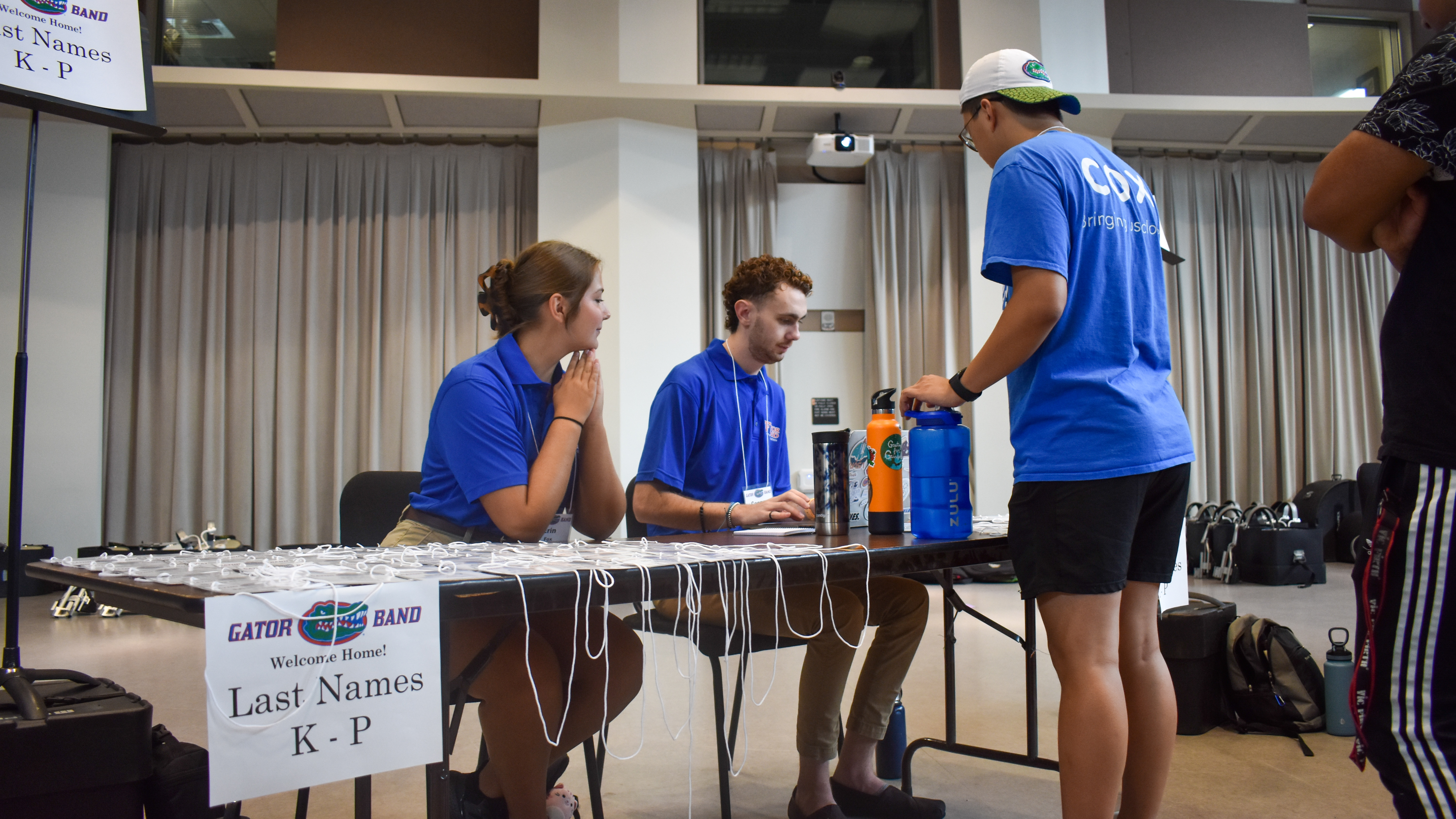 Two students sit at a table and check in a student.