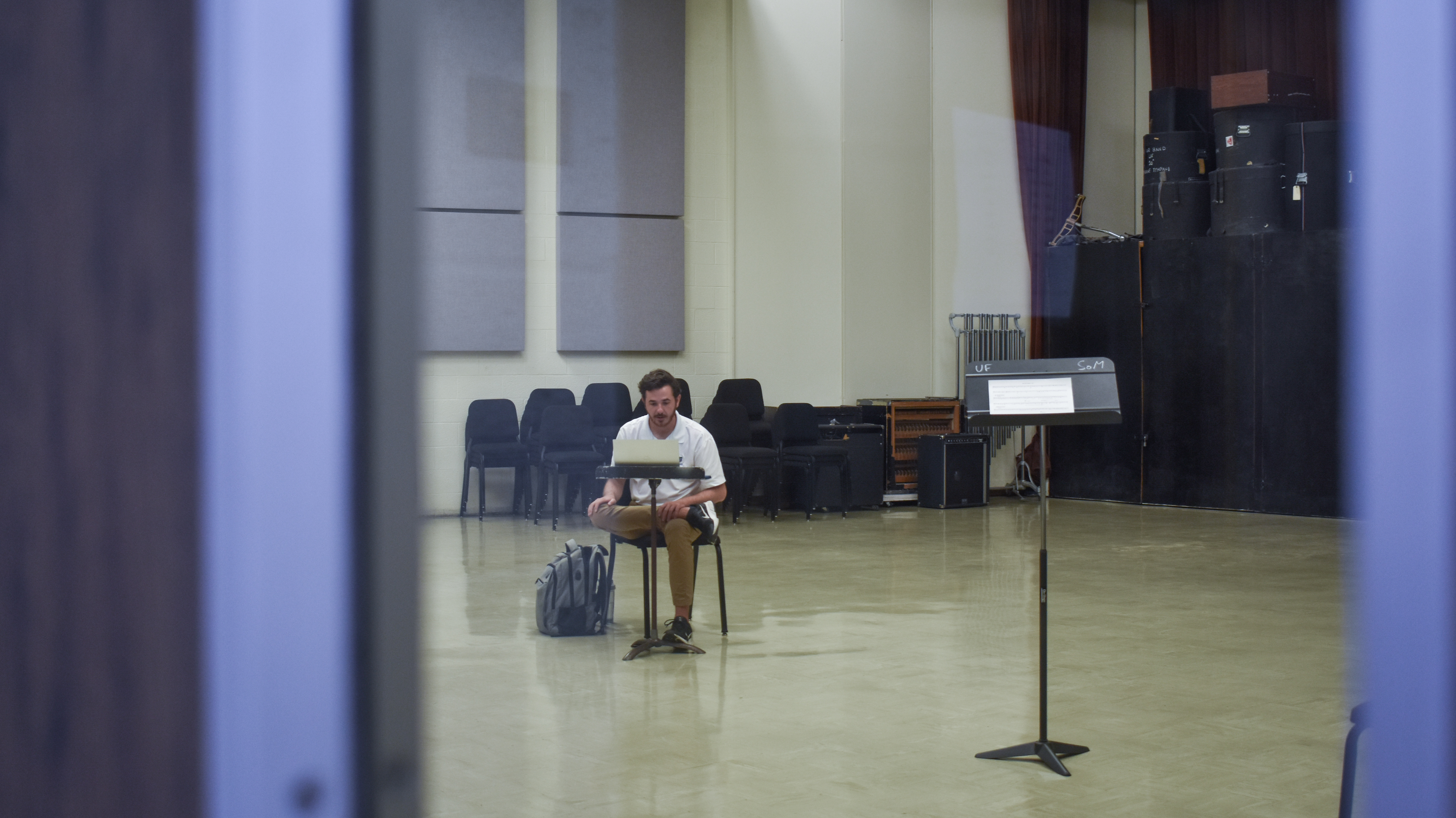 A man sits in a room with a computer.