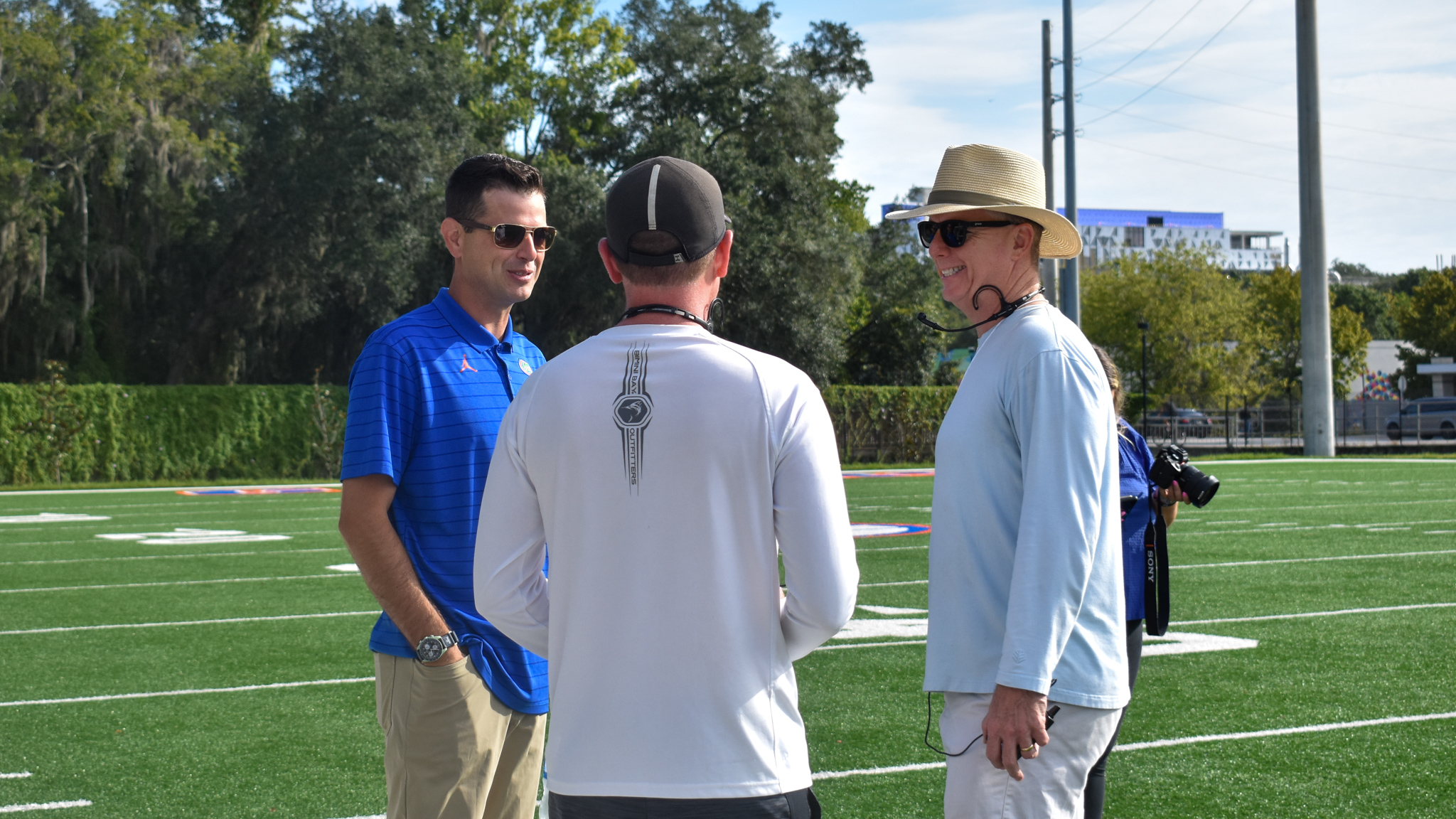 Three men talk in a circle.