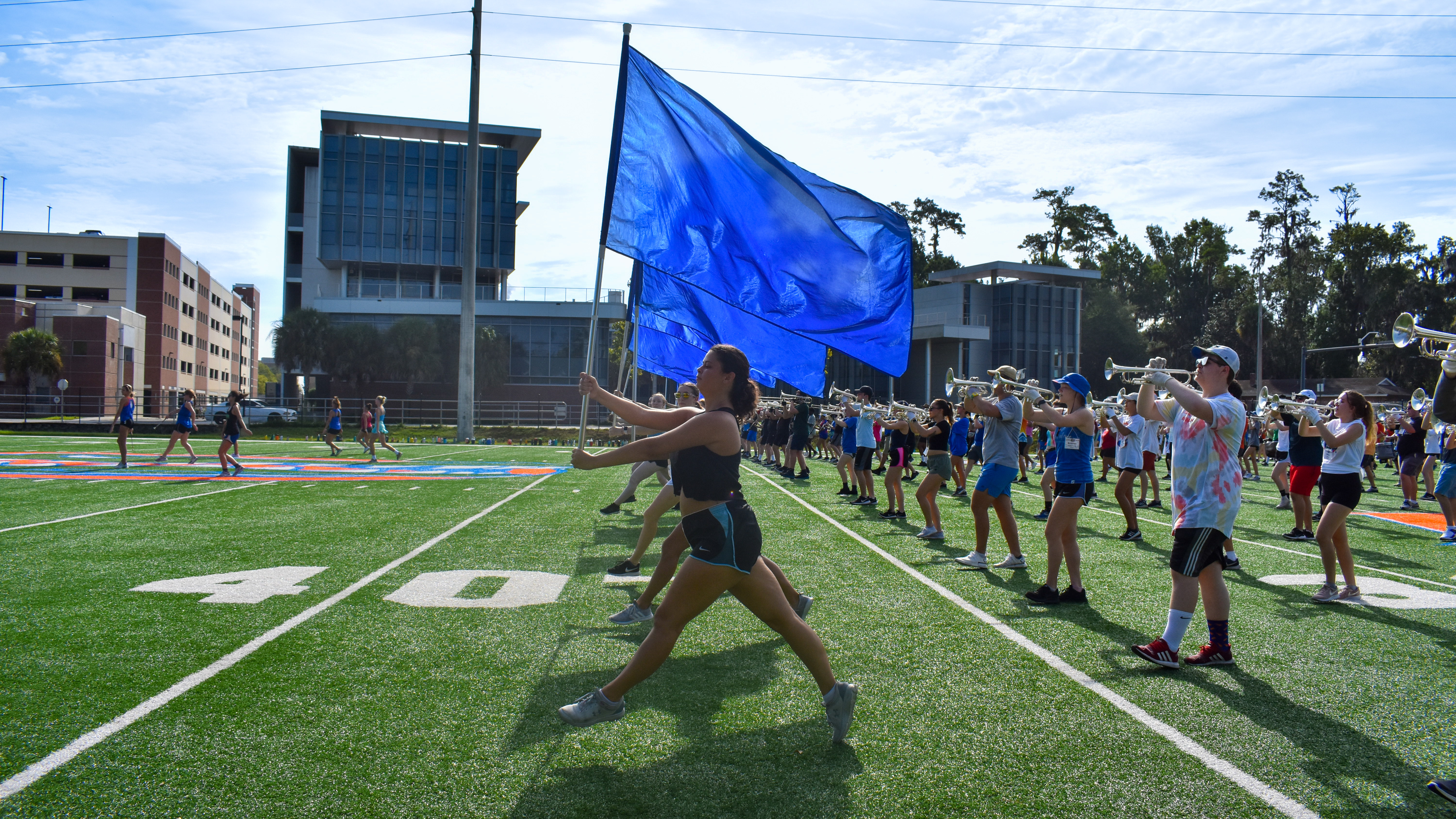 A color guard runs across a football field.