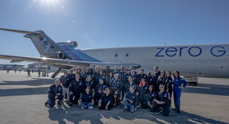 About 30 crew members of the AstroAccess flight on the tarmac in front of plane