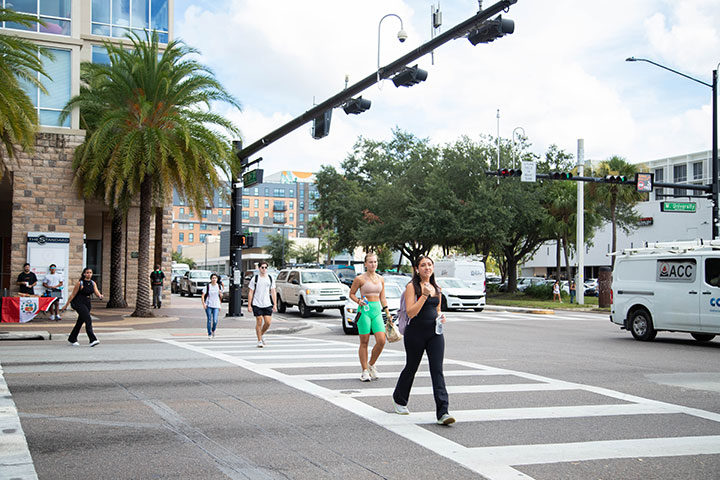 An image of people crossing University Avenue at 13th Street near the campus.