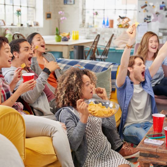 People on a couch watching a sporting event