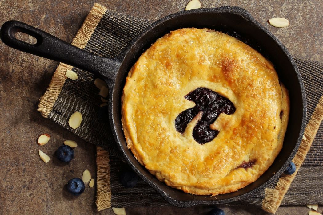 A cast iron pan with a pastry topping with the shape of pi cut out of it