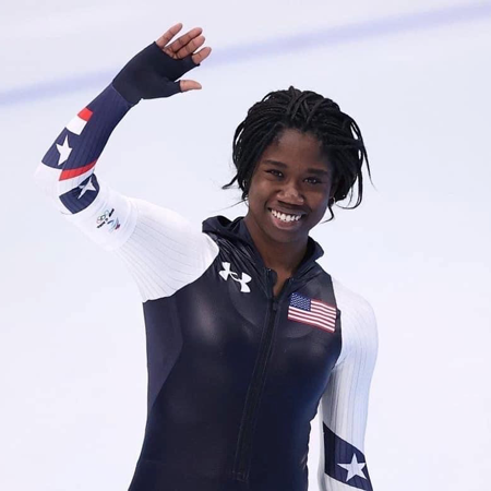 Olympic gold medalist Erin Jackson waving on an ice rink.