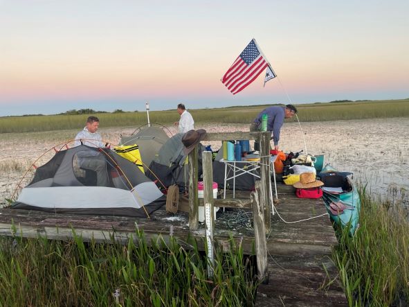 Canoe teams set up camp on a wooden platform in the Everglades