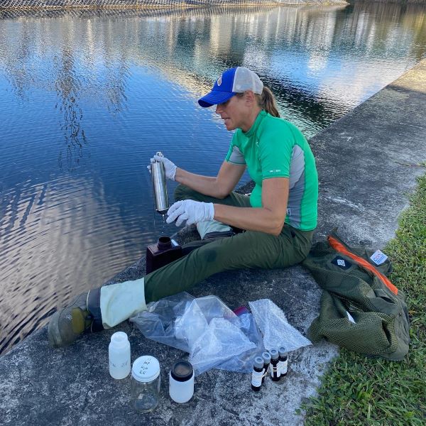 Tracie Brown sits on seawall organizing water samples from expedition
