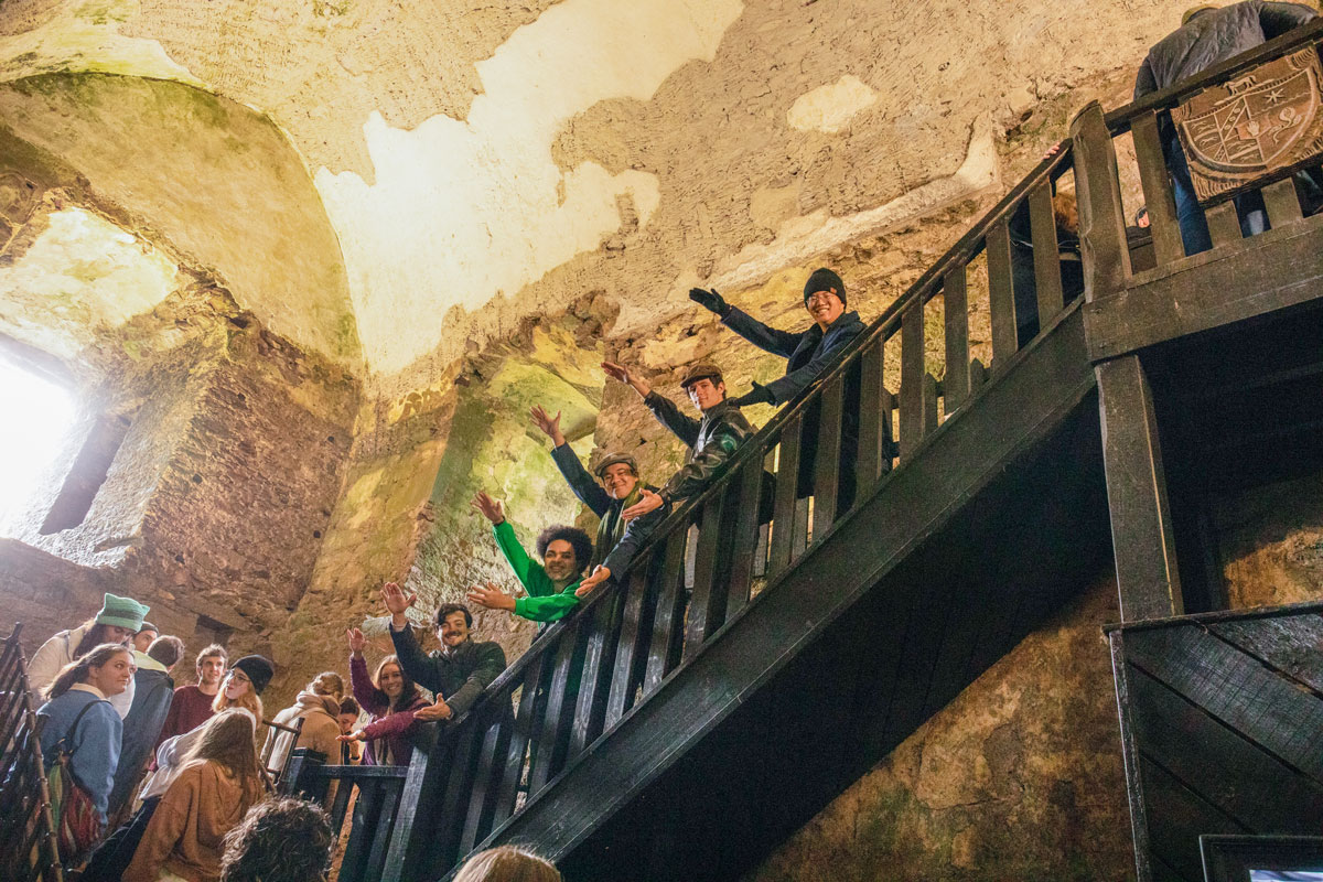 A group of students do a Gator Chomp in Blarney Castle