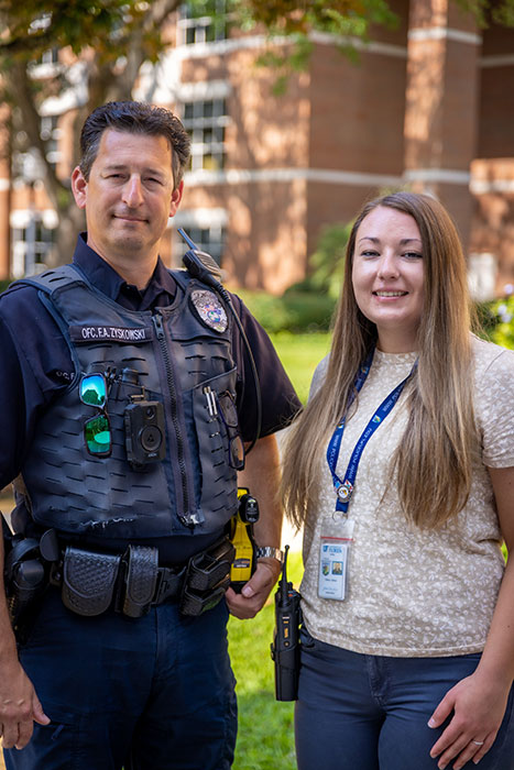 An officer and a civilian counselor look at the camera.