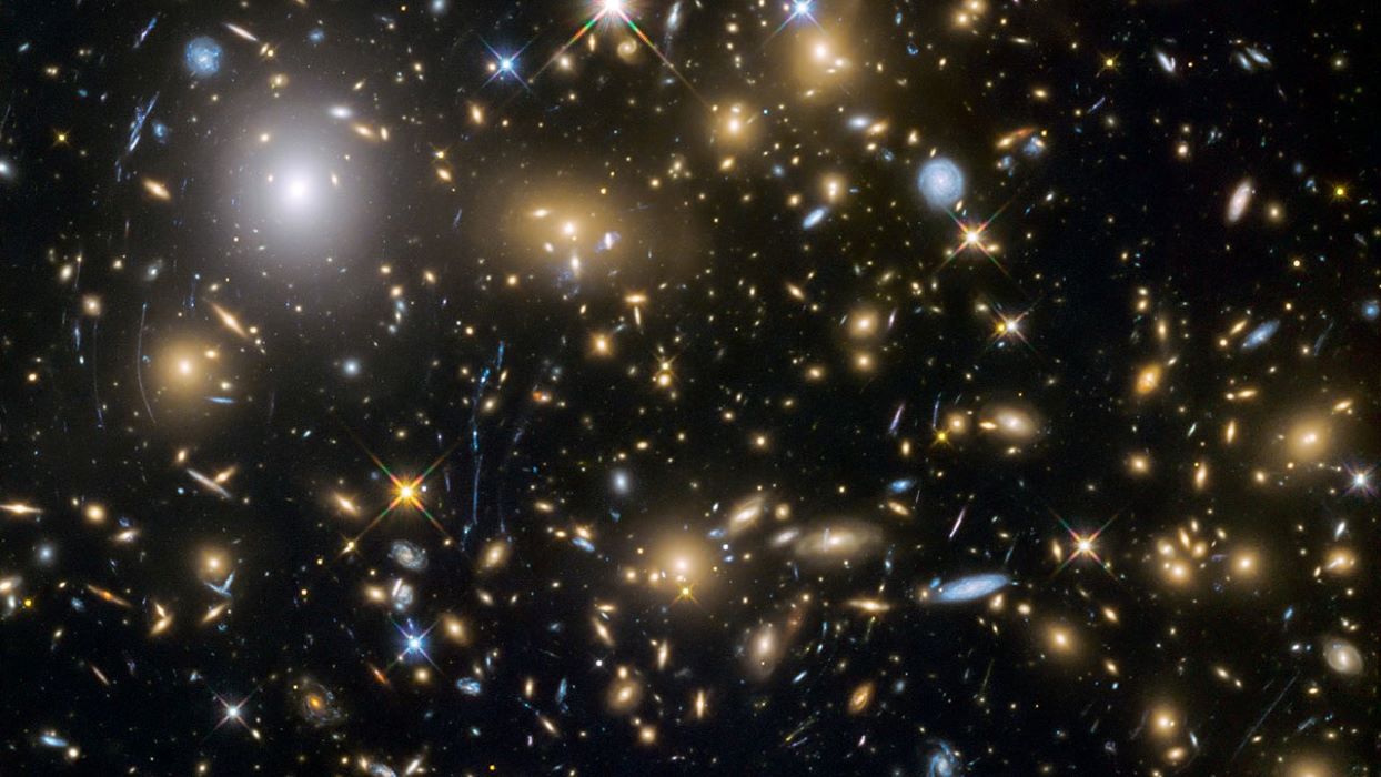 A telescope image showing hundreds of galaxies against a dark sky