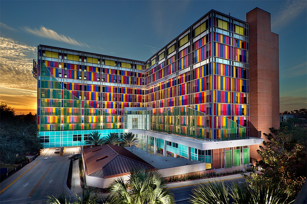 The front facade of Shands Children's Hospital showing multicolored windows lit at night