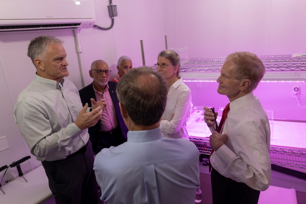 Rob Ferl addresses a group of scientists in a laboratory