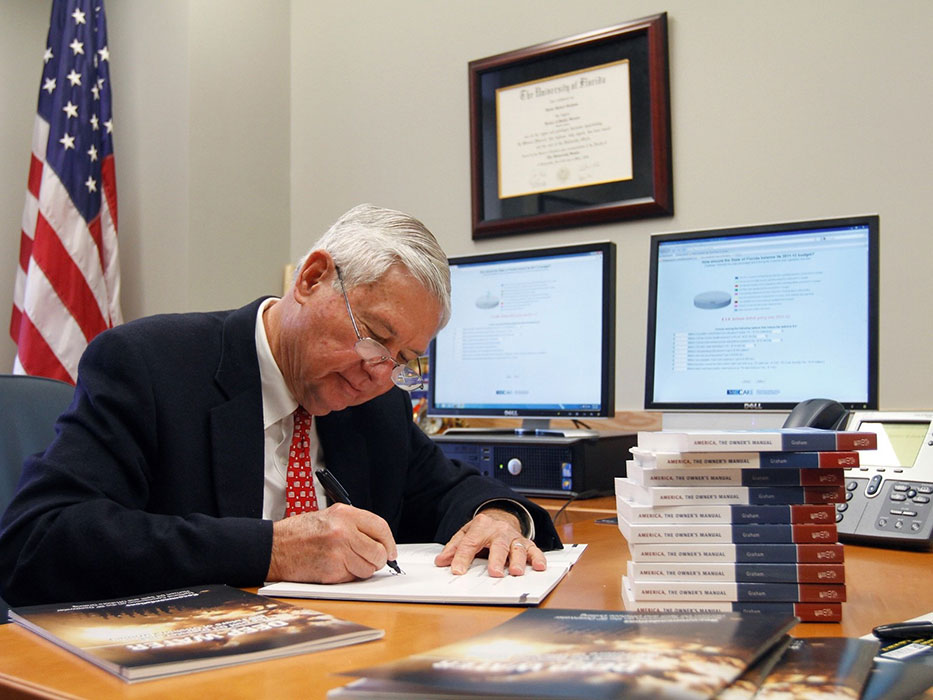 Former Sen. Bob Graham works from his desk at his office in Pugh Hall.