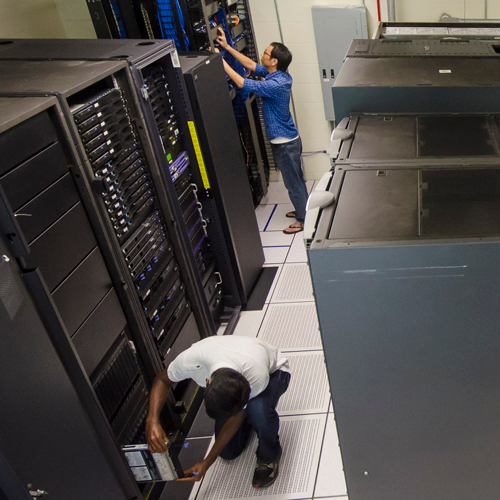 Two people working on a supercomputer