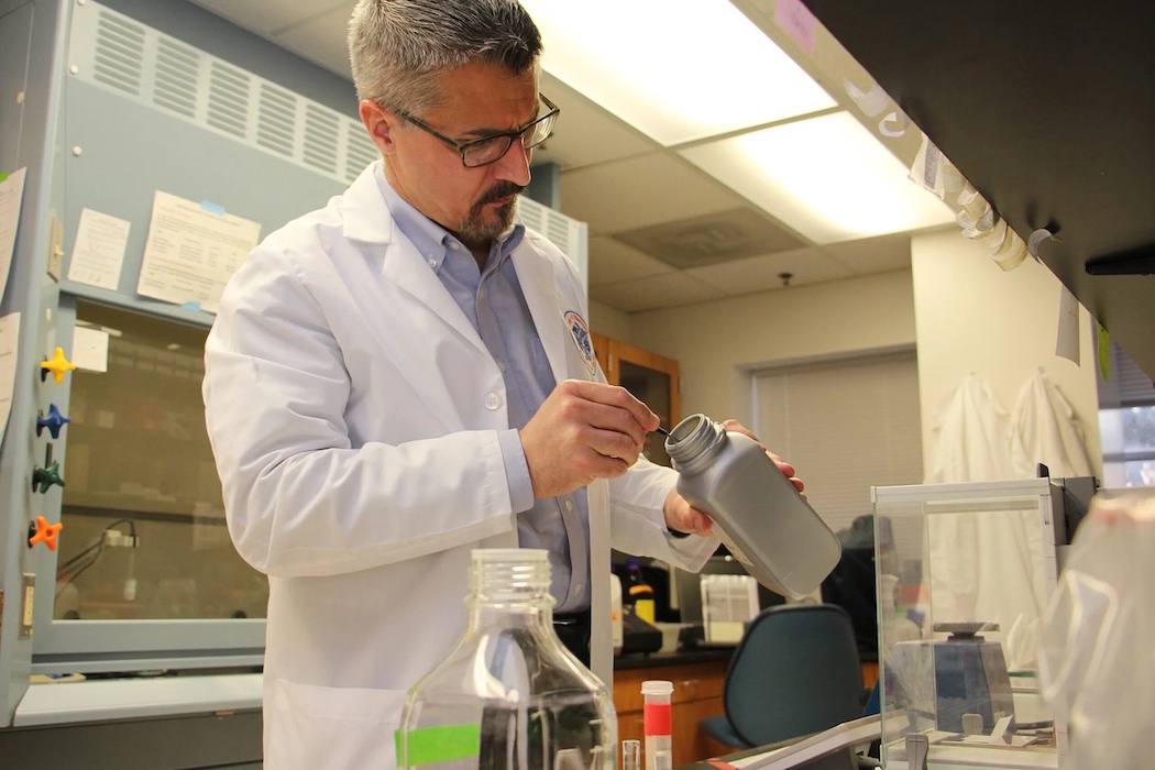 A scientist in a lab coat mixing chemicals in the lab