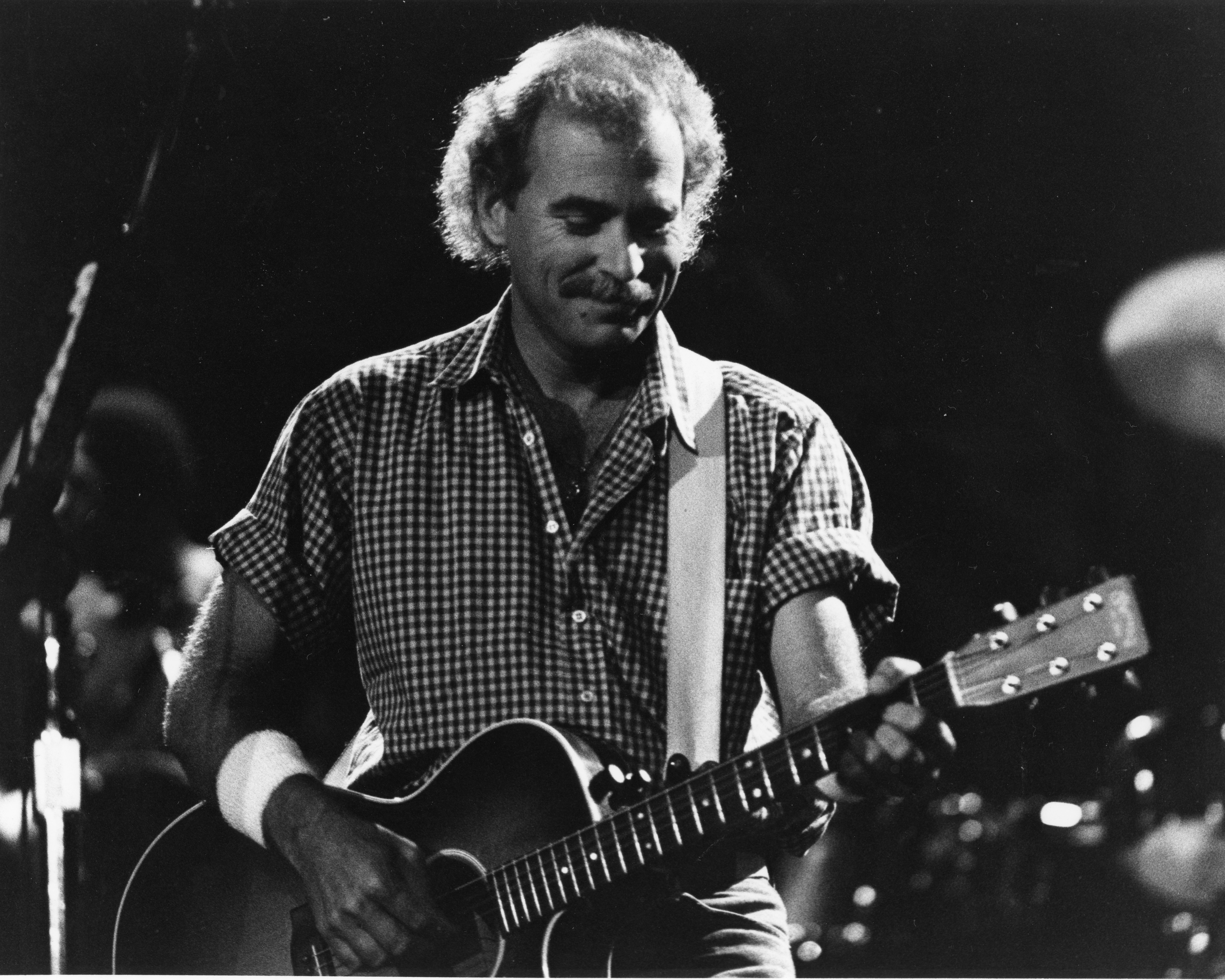 Jimmy Buffett playing guitar at UF's O'Connell Center.