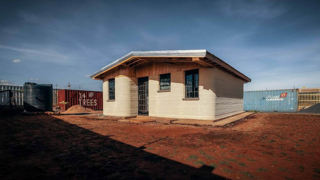 a house constructed with a 3D printer sits on piece of land