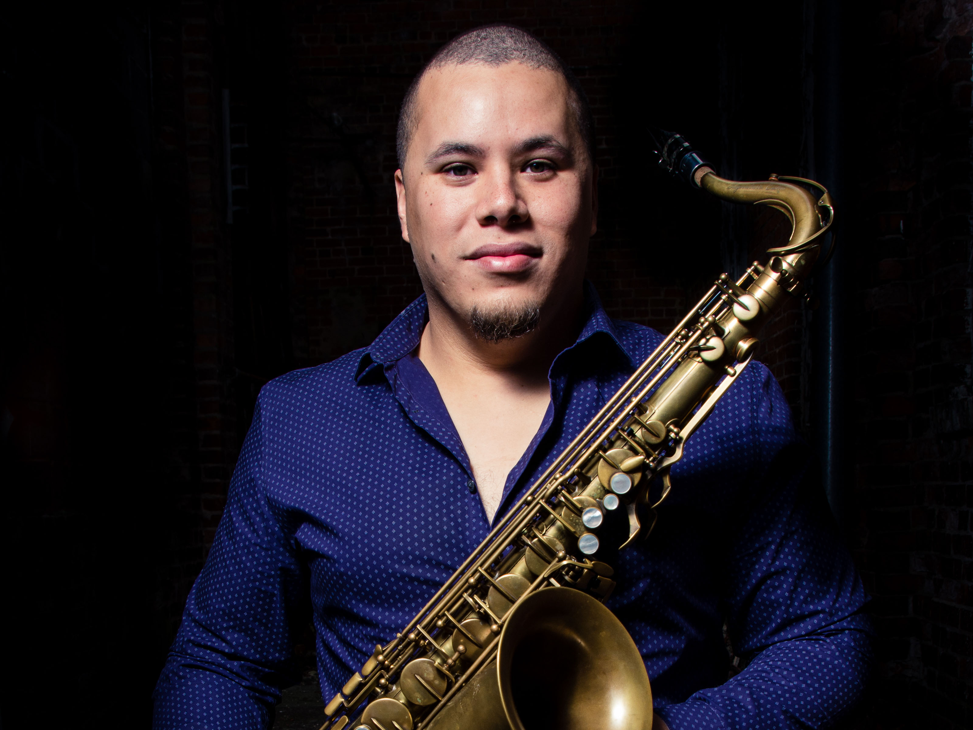 Jose Valentino Ruiz, Ph.D. holding a saxophone