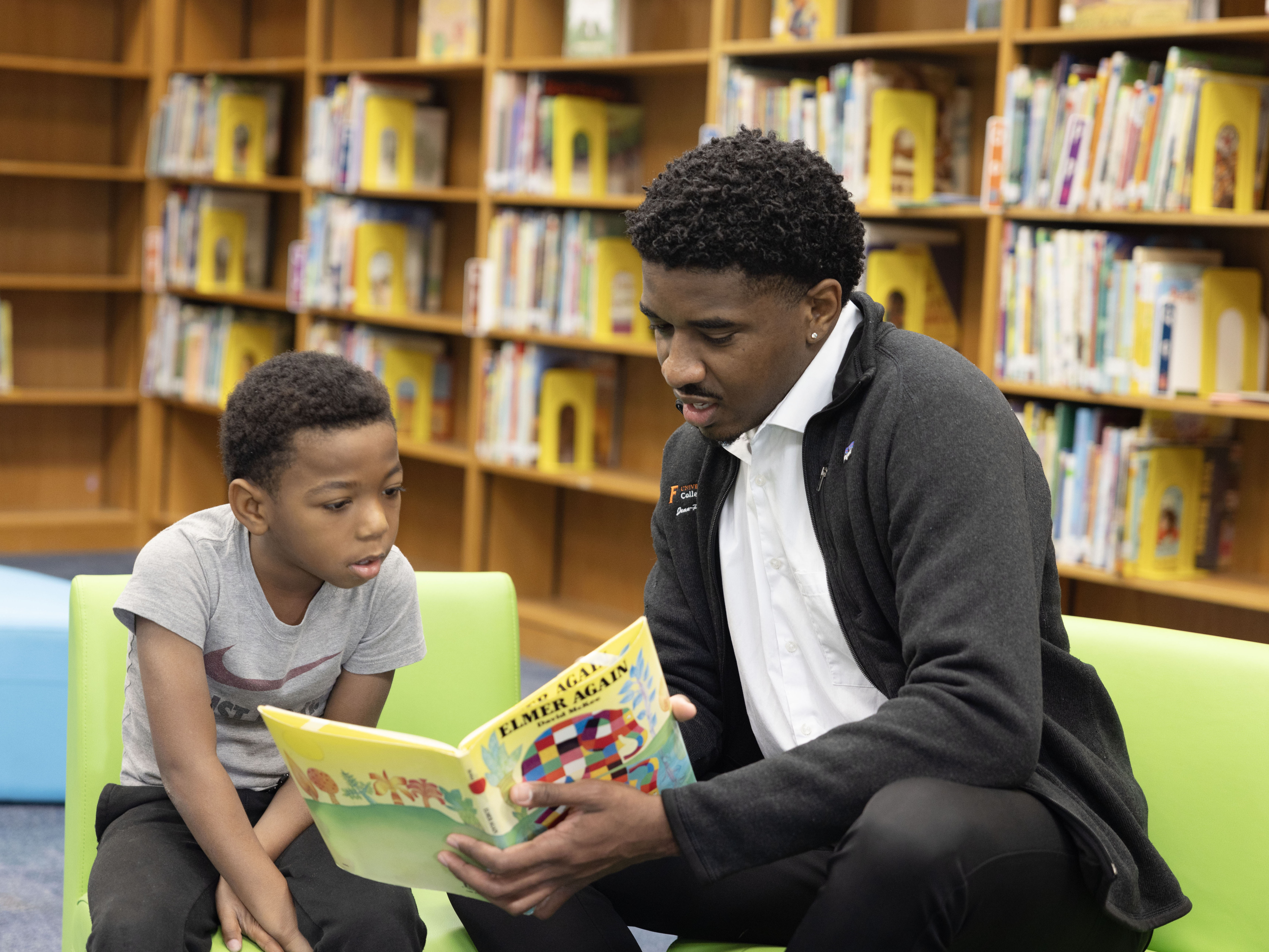 Medical student reading to elementary student