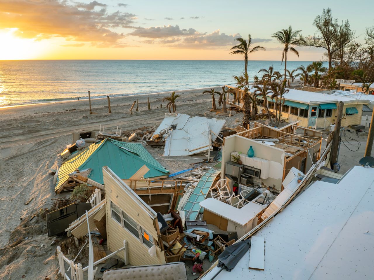 A severely damaged home along a Florida beach at sunset