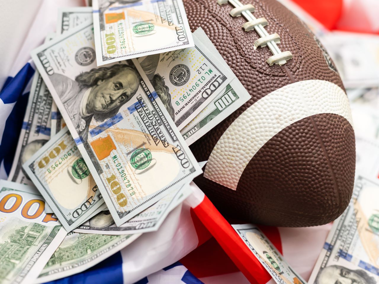 A football covered in hundred dollar bills