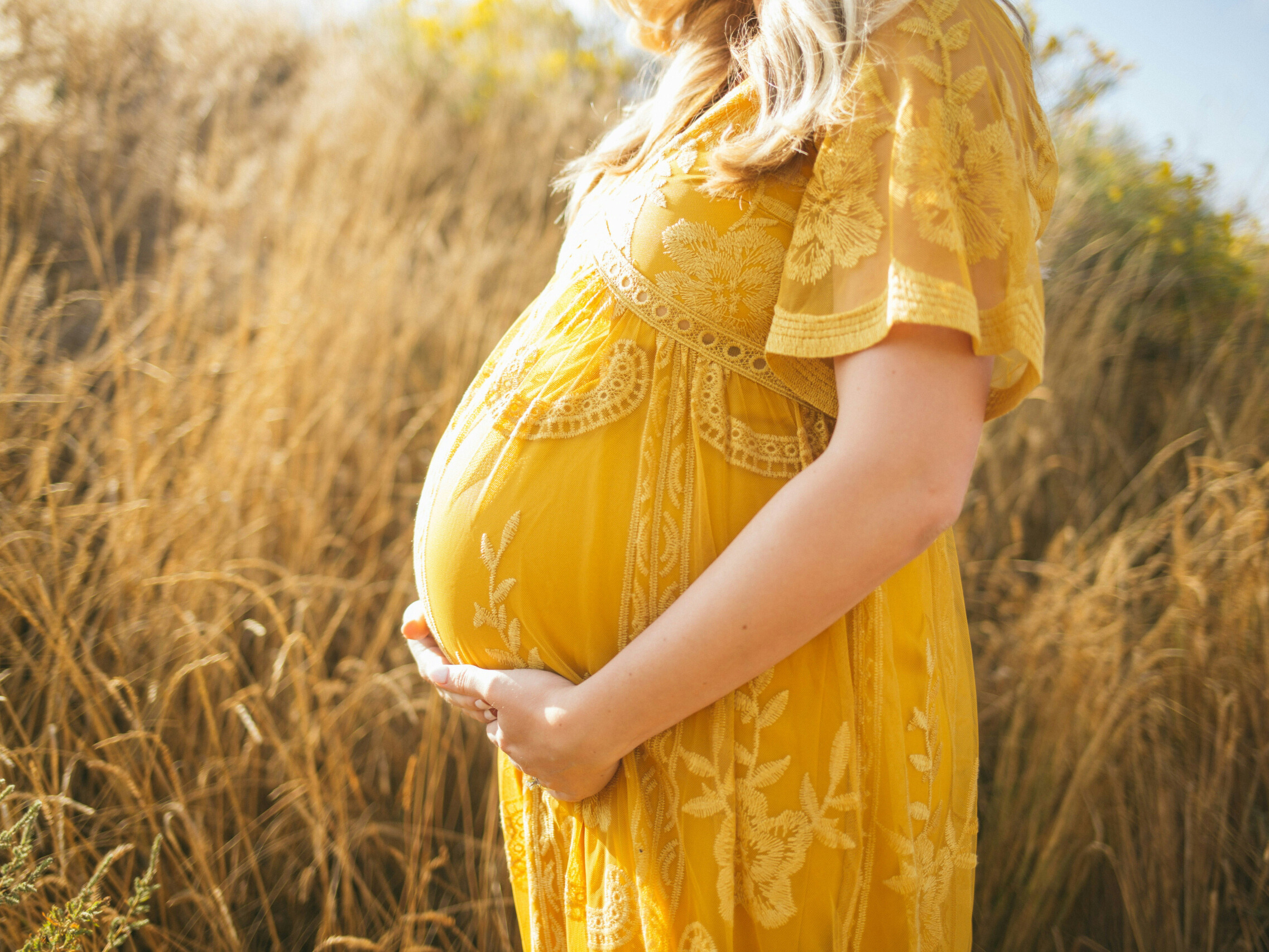 A pregnant woman standing in a field