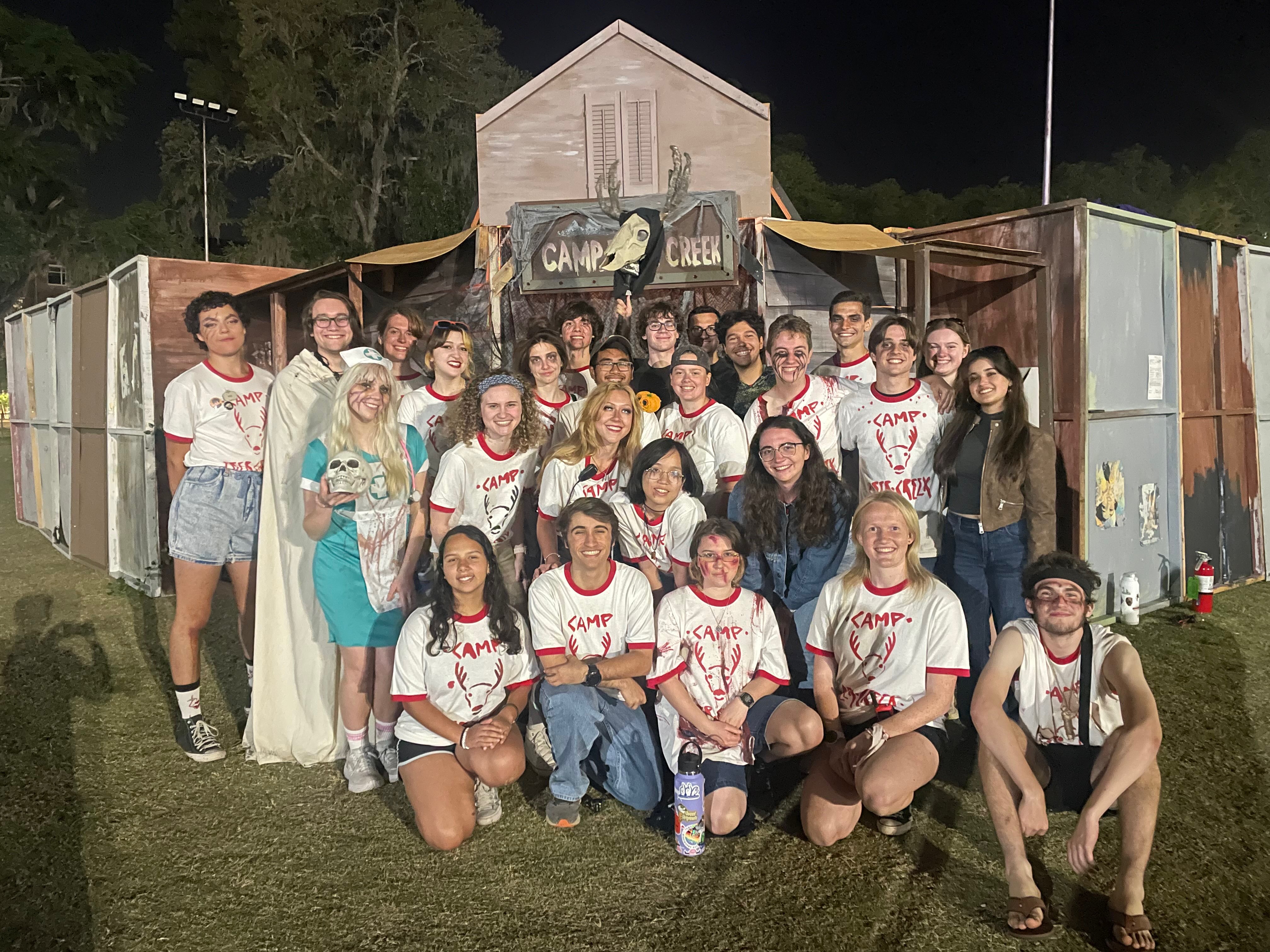 A group of students from Swamp Haunters standing in front of a haunted house